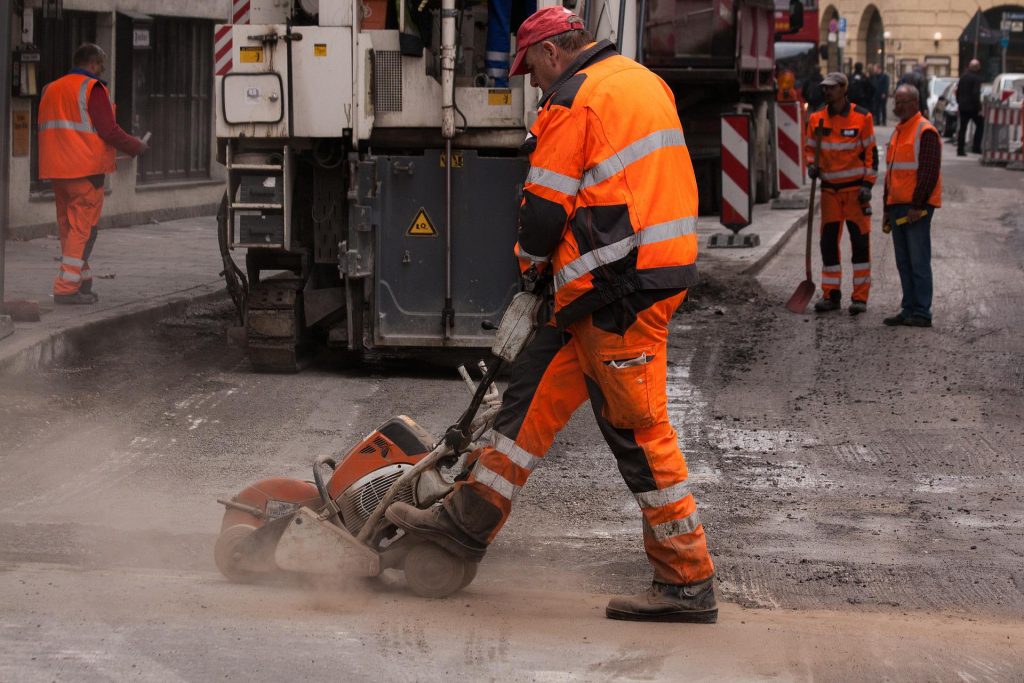 A man in Ireland is operating a concrete saw while wearing safety boots.